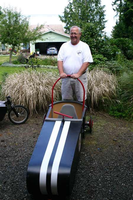 Chuck Strahm stands with Michael Galloway’s coaster car. Strahm and Michael built the coaster together as part of a new volunteer program to help kids build their own coasters.