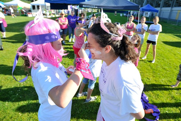 Liza Snyder rubs sunblock on her friend Lindsay Little's face Saturday as part of a sunblock awareness contest during the 24-hour North Kitsap Relay for Life at the North Kitsap Stadium.