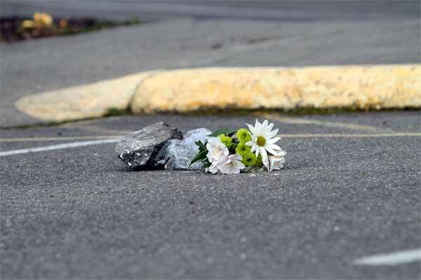 A bouquet of flowers was placed in a parking space adjacent to Poulsbo's First Lutheran Church following the death of a 64-year-old woman Tuesday night. A rock prevents the bouquet from being blown away by strong winds.