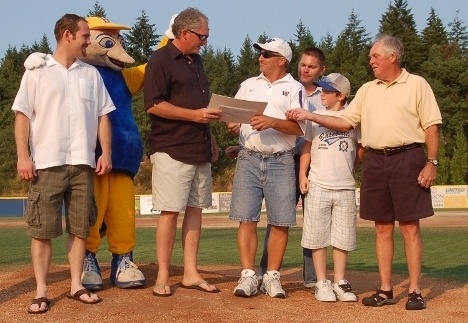 Rotary member Jeff Forville hands Bremerton's Randy Holliday a check for $16