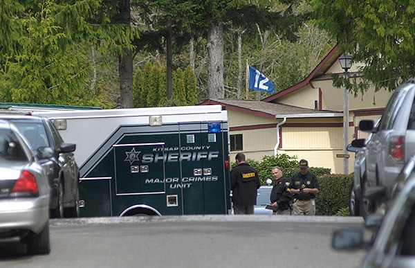 Officers stand near a 'Major crimes unit' van at Kariotis Mobile Home Park on March 28.