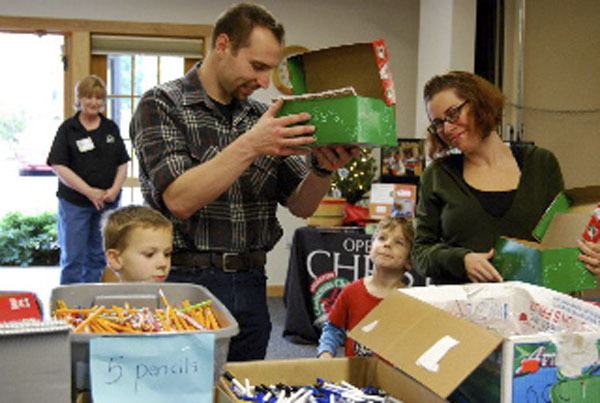 The Kotelnicki family filling shoeboxes at the Community Packing Party Nov. 17.