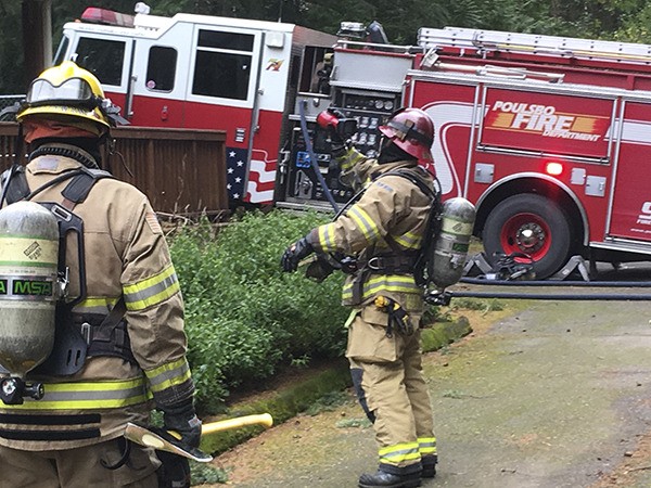 A firefighter utilizes his thermal imaging camera to scan the building for hot spots.