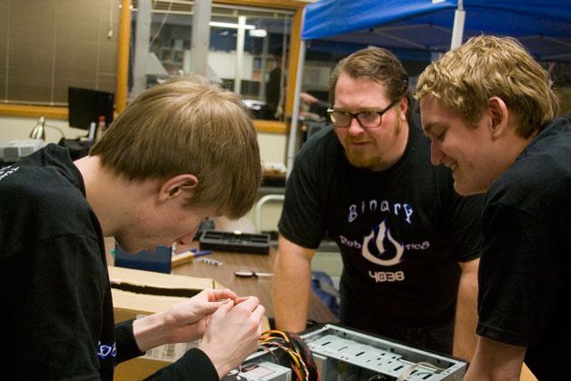 Olympic High School teacher and robotics team advisor Brandon Brown consults with Steven Parkins and Chance Phelps as the two students work in Brown’s computer repair class. Both Parkins and Phelps are members of the Binary Robotics team.