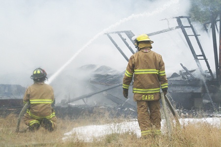 South Kitsap firefighters douse a burning mobile home Monday afternoon.