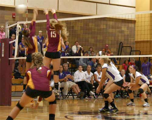 Two Kingston High School varsity players jump up to block the volleyball during the second match against North Kitsap Tuesday night. North Kitsap left Kingston with a 3-0 victory.