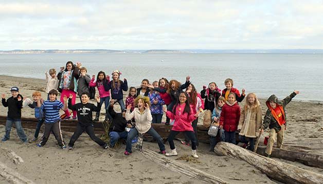 Clear Creek Elementary students pose as 'crabs' on the beach located just below the  Pt. Townsend Marine Science Center’s pier. The students studied marine life at the center.