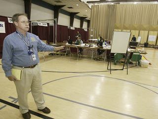 Kitsap County Department of Emergency Management Operations Coordinator Mike Gordon shows the mock call center set up at the Kitsap Fairgrounds Pavilion this week for Diablo Bravo