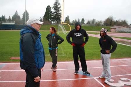 Head coach Daryl Schruhl leads the Olympic College distance track team at Bremerton Memorial Stadium earlier this month. The school’s track