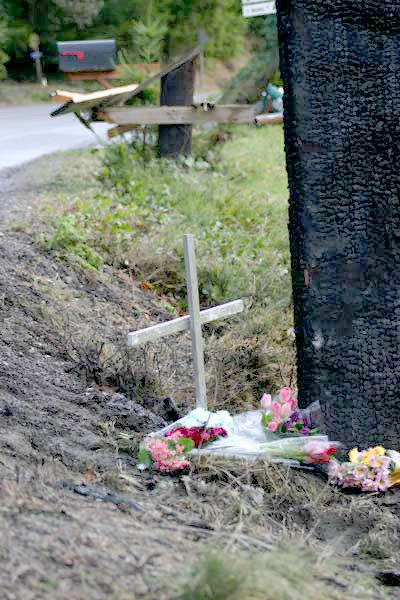 Remembrances mark the site of a fiery crash that killed two people Saturday morning.