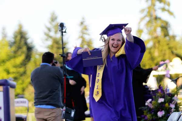 North Kitsap High School graduate Cassidy Callaham points to family after walking across the stage to receive her diploma June 14 during the graduation ceremony for the class of 2013 at North Kitsap Stadium.