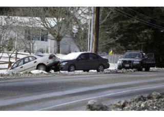 A Kitsap County Sheriff’s deputy responds to two cars left behind by their owners on Bucklin Hill Road in Silverdale Monday morning. Local law enforcement responded to several collisions and abandoned cars as more than 3 inches of snow covered the county Sunday evening into early Monday morning. Many local school districts had delayed start times.