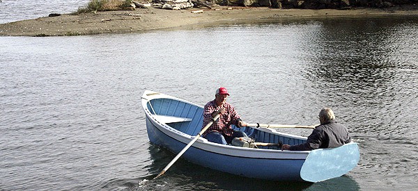 Joe Schwan rows a 65-year-old Poulsbo boat with Richard Meyers as passenger. Meyers restored this boat