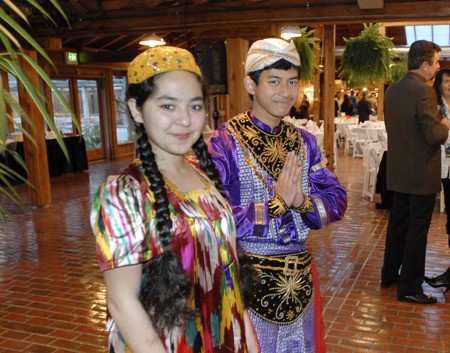 Shabnami Kakhkhori wears a traditional Tajik dress at a West Sound Academy fundraiser March 6. Next to her is Indonesian exchange student Muhammad Ardiyansyah.