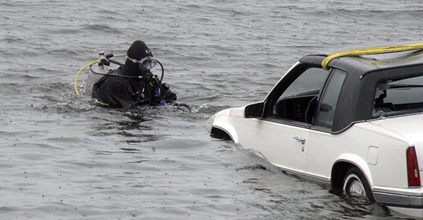 A Suquamish Police diver helps extricate a car out of Sinclair Inlet Thursday morning. The driver of the vehicle was rescued and is being treated at Harrison Hospital in Bremerton.