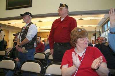 Veterans stand during a ceremony honoring the 100 birthday of the Retsil Veterans Home Monday.