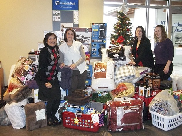 Employees at Columbia Bank hold stars that contain gift suggestions for foster kids. Debbi Brooks-Givens