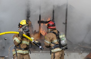 Firefighters work to douse the flames in a doublwide mobile home fire that brokeout about 2:40 PM Tuesday in the Gamblewood neighborhood. The structure was a total loss.