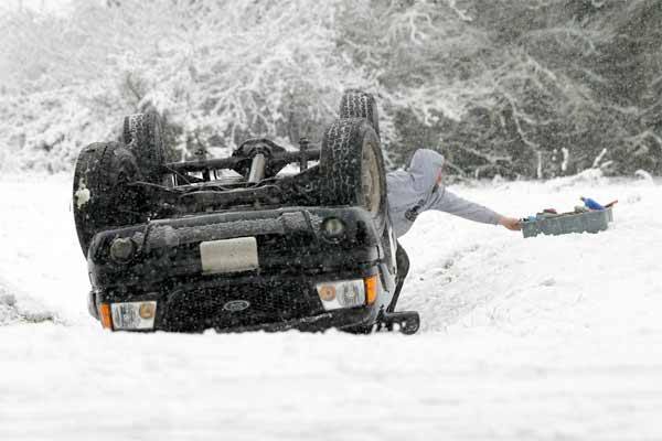 A man pulls tools from a truck after a single-vehicle rollover crash on Stottlemeyer Road Tuesday morning. No injuries were reported.