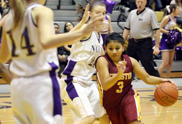 Kingston's Napua Fontes bursts past North Kitsap's Indika Bray Tuesday night during the last basketball game of the regular season. Both Kingston and North Kitsap advance to sub-districts Feb. 9.