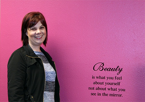 One of the best places in Elaine Turso’s new location is her hot pink wall where a reminder about beauty is painted. She now has rooms for all her props and fashions.