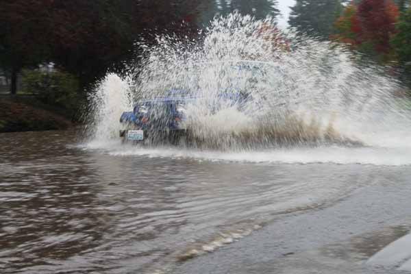 A Jeep splashes through 7th Avenue near the Doctor's Clinic in Poulsbo before the road is shut down.