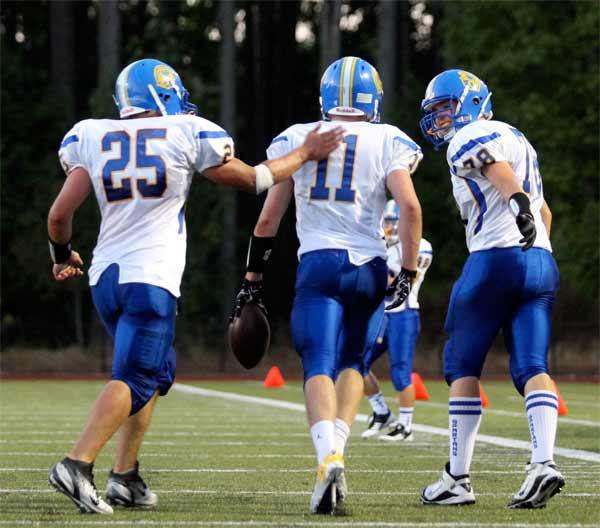 Fellow Bainbridge Island High Spartans congratulate kicker Sam Kallas after making a two-point conversion Sept. 7 at Buccaneer Field. The Spartans varsity football team defeated the Kingston Buccaneers 43-6.