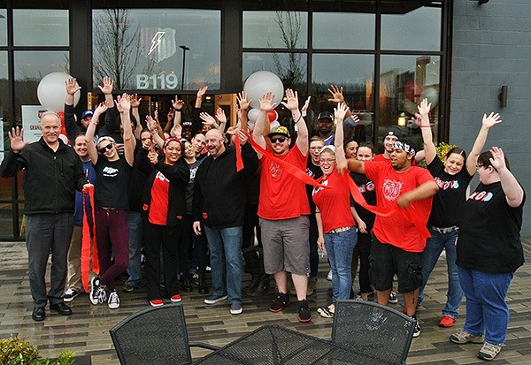 TOP: MOD Pizza employees raise their hands in the air to celebrate the grand opening of their restaurant during a ribbon cutting ceremony on Saturday