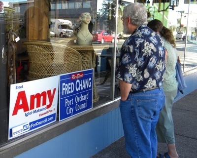 Off the Wagon Antique Market owner Kelly Berg posts signs from opposing city council candidates.