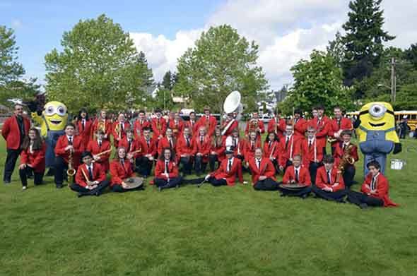 The Ridgetop Junior High ‘Red Raider Band’ poses with two minions characters from the movie 'Despicable Me' during the Armed Forces Parade in Bremerton.