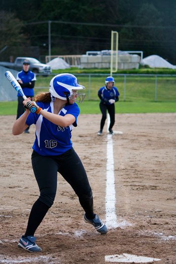 North Mason pitcher Kimber Bolin steps into her swing as her teammate takes off toward home. Bolin hit the Bulldogs' fourth inning home run that tied the game at 5.