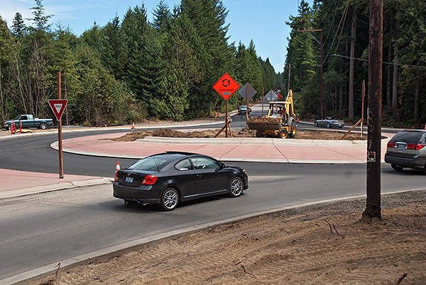 Motorists zoom around a new roundabout being constructed at the intersection of  Seabeck Highway NW and NW Holly Road on Aug. 4. The $1.9 million project will also widen the road and add shoulders to improve safety. Seton Construction is doing the work. The project is scheduled to be finished in November.