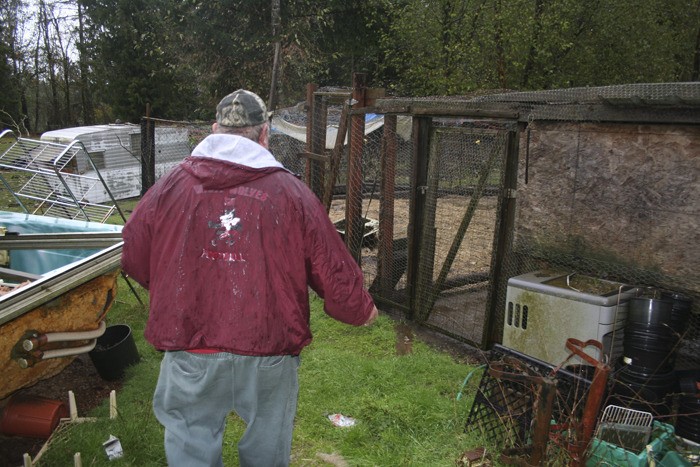 Simon Bailey walks by some of the animal pens on the 5-acre farm where he and his wife live near Olalla.