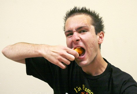 Poulsbo’s Victor Dew takes a bite of a habanero pepper on July 13. Dew won $250 during a lutefisk-eating contest in Ballard on July 9. He plans to continue eating competitively and hopes to achieve two world records.