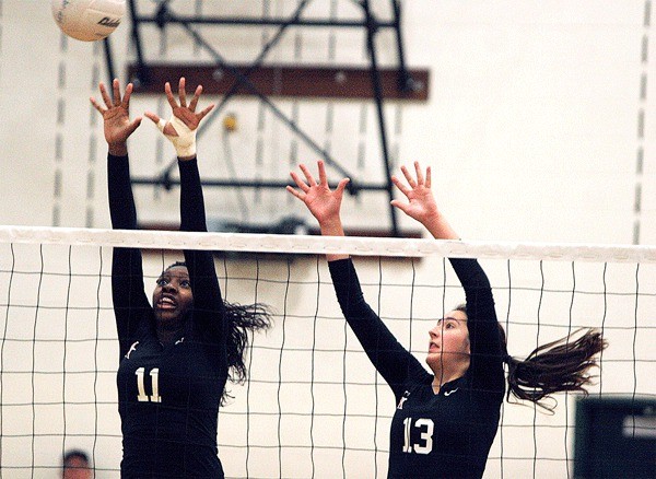 Kelsey Scott and Katie Thorsen rise to block a shot in the second set.