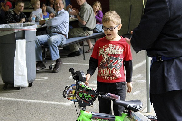 Pearson Elementary School first-grader Kye Brandon checks out his new ride at the Books for Bikes Challenge prize presentation