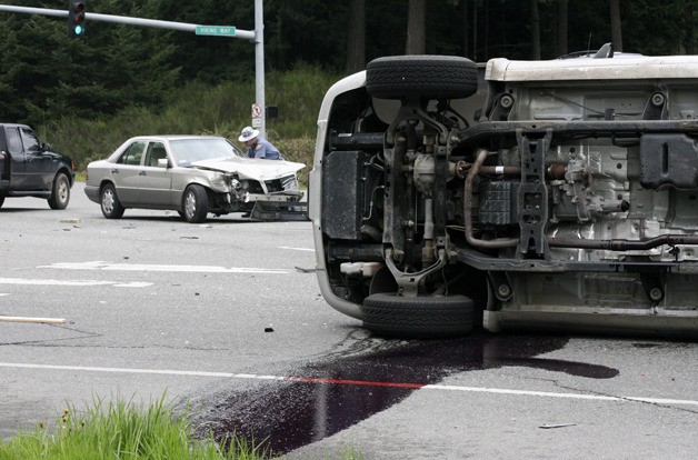 Transmission fluid leaks from a Dodge truck on State Route 305 Thursday after it collided with a Mercedes sedan.