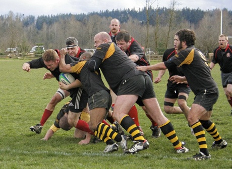 Members of the Kitsap Rugby Football Club (in black and red) play a match last spring.