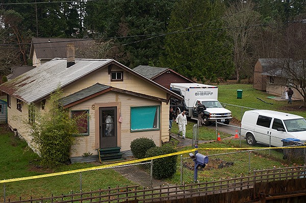 Law enforcement officers walk around a house in the 2000 block of NW Shamrock Drive in Bremerton Dec. 15 during a homicide investigation.