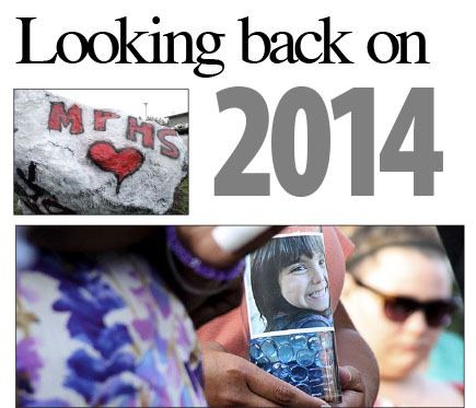 Top: North Kitsap High School students paid tribute Oct. 28 to the shooting victims at Marysville-Pilchuck High School. Above: an image of Jenise Paulette Wright adorns a candle at the Aug. 8 vigil. The six-year-old girl was found murdered five days after she was reported missing.