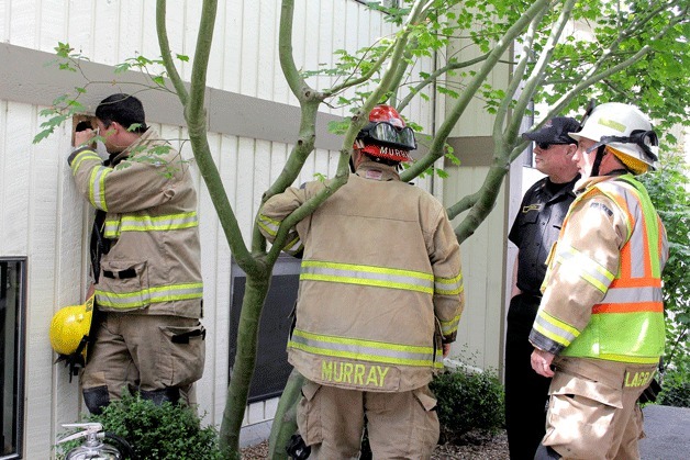 Firefighters examine a dryer vent after a fire started inside Wednesday morning