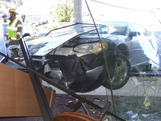 A 77-year-old Poulsbo woman was uninjured after driving her car through the window of Dahlquist's Fine Jewelry in the Poulsbo Village Sunday.