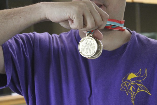 North Kitsap’s Richard Heckly shows off his gold medal for the 50-meter Backstroke and silver medal for 50-meter Freestyle that he earned at the 2012 Special Olympics Washington Summer Games June 1-3.