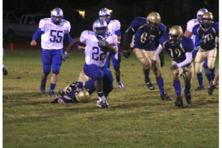 (Above) Olympic senior running back Larry Dixon rushed for 267 yards and two touchdowns on 38 carries to lead the Trojans (6-3) past Bremerton (2-7) at Memorial Stadium Oct. 30. (Below) Trojan Richard Stieger goes for a sack against Billy Davenport of Bremerton.