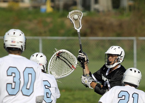 The 2012 North Kitsap Lacrosse team works to block a Klahowya attacker during a league game in April