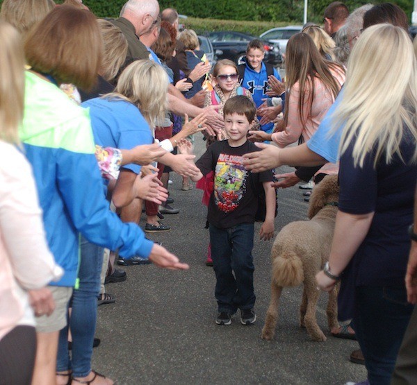 First-grader Dylan Franklin is greeted by South Colby Elementary School teachers and staff members