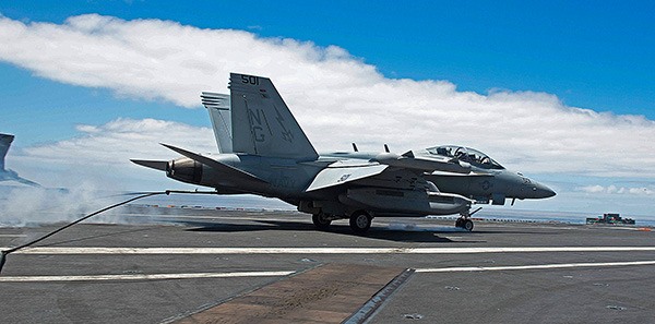 Cdr. Blake Tornga catches an arresting hook gear wire in an EA-18G Growler after assuming command over the Wizards of Electronic Attack Squadron (VAQ) 133 during an aerial change of command ceremony above the USS John C. Stennis.