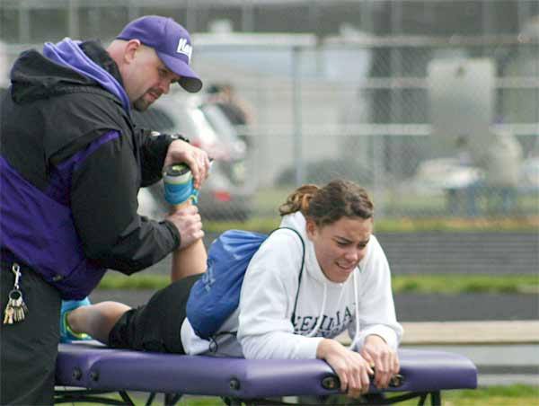 North Kitsap Athletic Director Chris Franklin helps an injured track runner in 2011 during the Lil' Norway Invite. Franklin played a key role in developing the athletic medicine program at both North Kitsap and Kingston high schools.