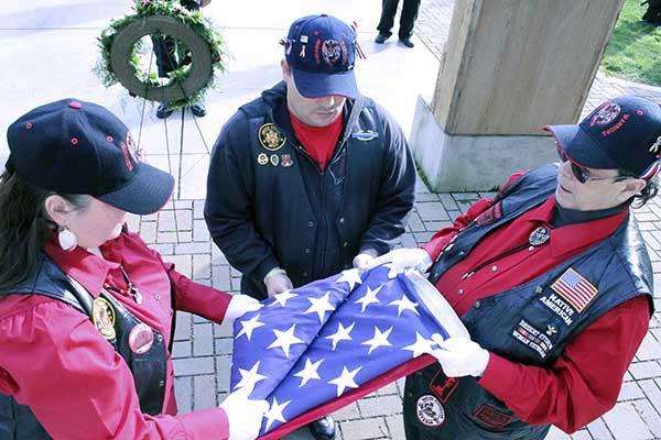 Members of the Suquamish Warriors Color Guard fold the flag for presentation to the family of Spc. 4 John M. Lazzaretti