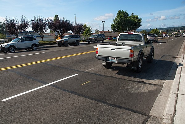 Motorists drive over patched-up section of Silverdale Way in Silverdale on July 22. The patches are the result of a project that installed new water mains. Some people think the road is too bumpy and should be fixed with a new overlay of asphalt.